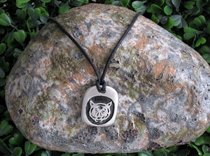 Year of the tiger Chinese zodiac pendant necklace for unisex, squarish pendant with black background, cotton cord style. (picture taken on a background with a rock)