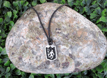 Load image into Gallery viewer, handmade pewter lacrosse player pendant necklace, pendant with black background, on black cord, for man or woman (picture of necklace taken on a background with a rock)