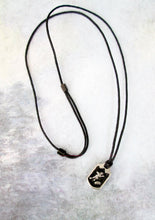 Load image into Gallery viewer, far full view of handmade pewter football player pendant necklace, pendant with black background, on black cord, for man or woman.