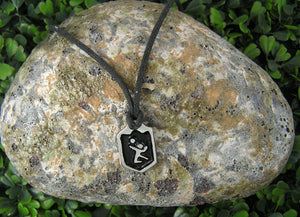 handmade pewter volleyball player pendant necklace, pendant with black background, on black cord, for men or women. (photo of necklace taken on a background with a piece of rock)