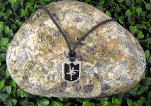handmade pewter dancer pendant necklace, pendant with black background, on black cord, for teen girl or woman. (photo taken on a background with a rock)
