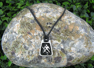 handmade pewter hockey goalie pendant necklace, polygon pendant with black background, for men or women, on black cord. (photo taken of necklace on a background with a rock)