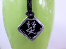 Load image into Gallery viewer, Kanji symbol of Laugh and Happiness pendant necklace, pendant with black background, black cord necklace style.