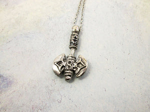 far view of handmade pewter Celtic axe pendant necklace, double blade, double sided. for man or women. pendant on metal chain. (photo taken on a gray background)
